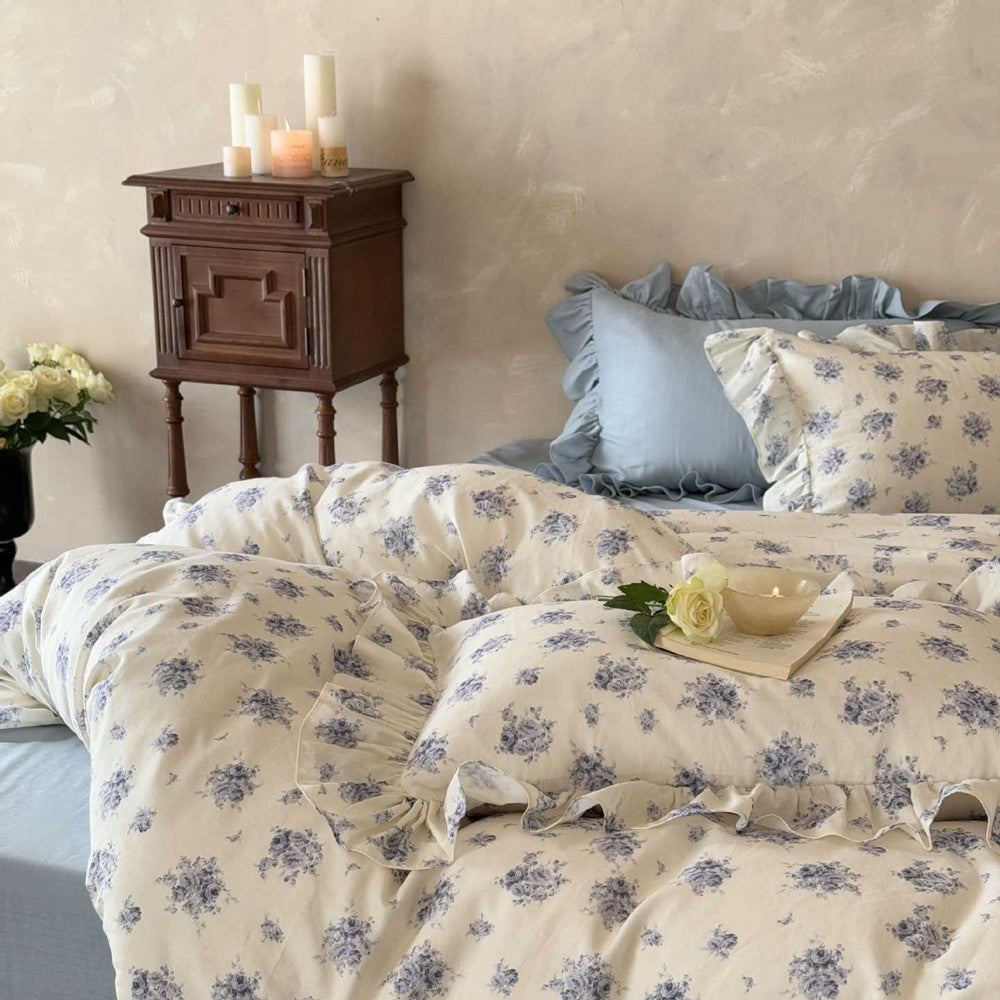 French Vintage Style blue rose floral cotton bedding set with candles on a bedside table.