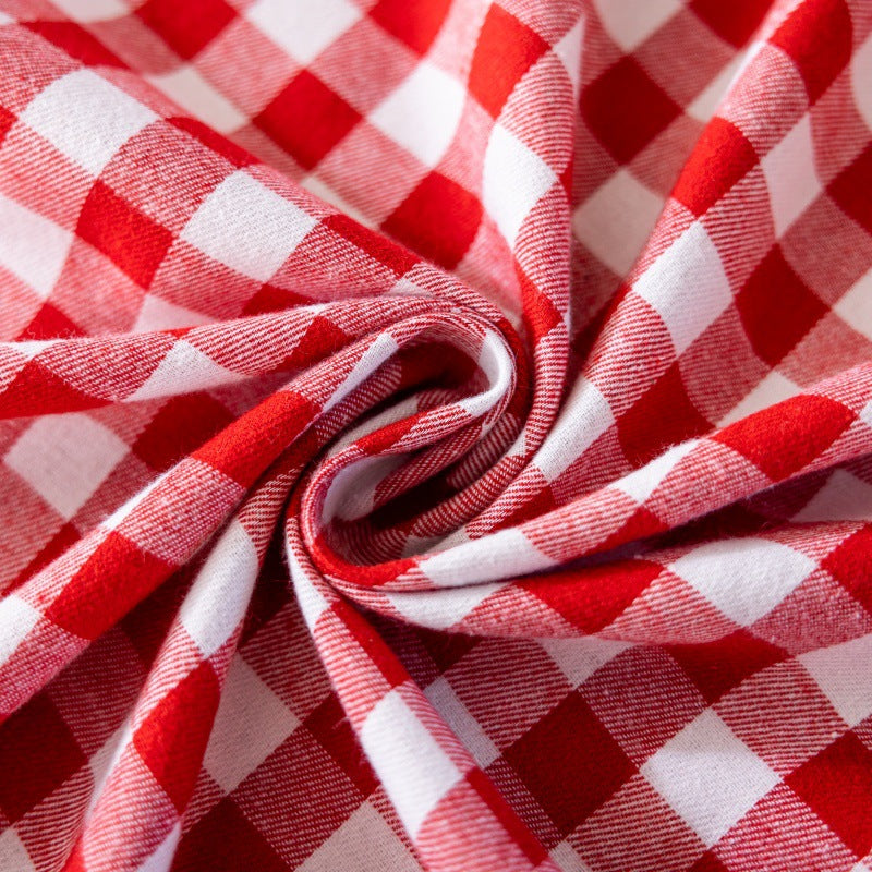 Close-up of red and white buffalo plaid cotton fabric with soft texture and folds