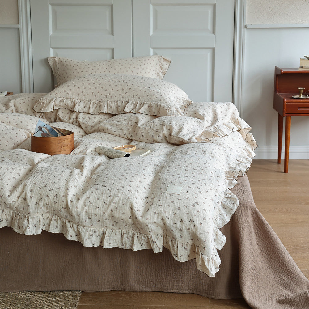 Close-up of a Cottagecore floral muslin duvet cover set with ruffles and a textured brown bed skirt, featuring a cozy bed scene with a wooden box.