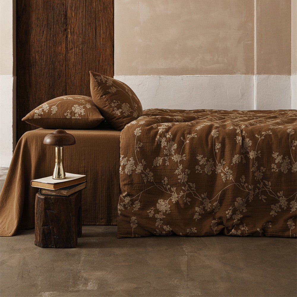 Close-up on the corner of the bed, highlighting the textured Brown Floral Cotton Gauze duvet and solid brown sheet