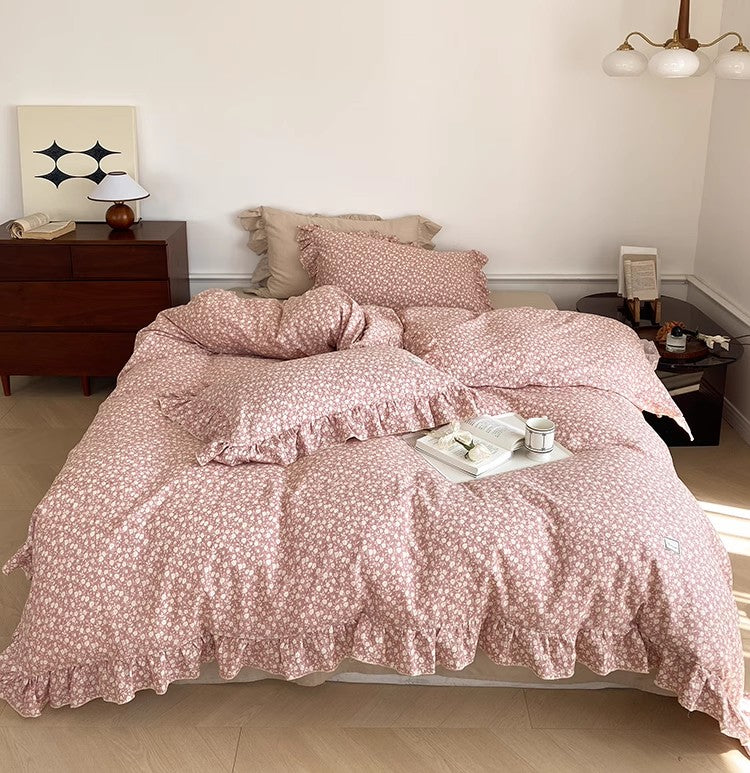 Full shot of the pink Ditsy Floral Bedding Set, showcasing the complete look of the cotton muslin duvet cover and shams with ruffled edges in a bright bedroom.