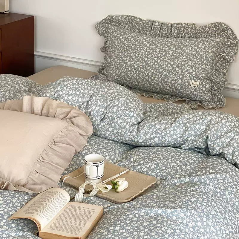 Overhead shot of the blue cotton muslin bedding set, emphasizing the ditsy floral pattern and the solid color pillow with ruffled edges.