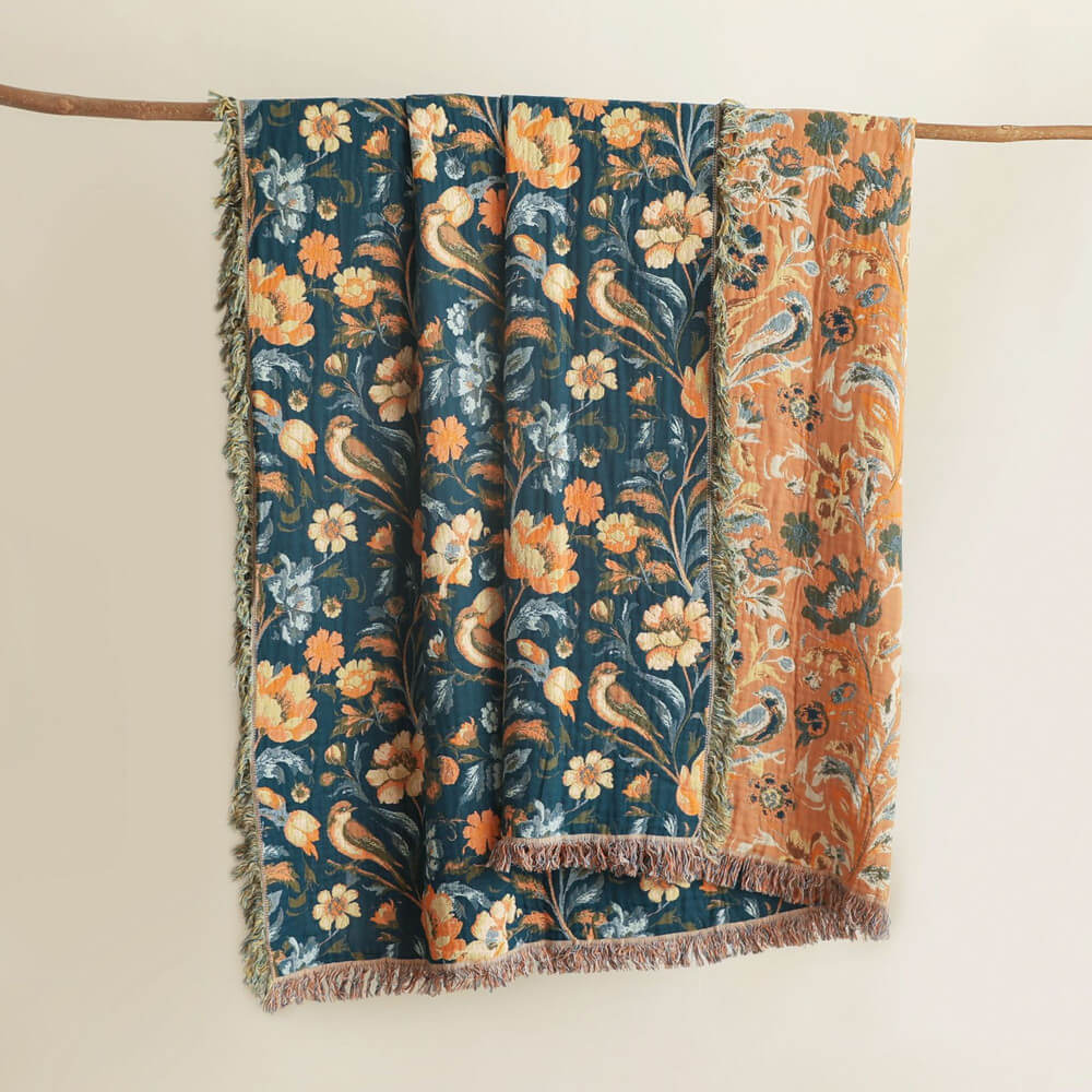 Reversible dark teal botanical cotton throw blanket showing warm terracotta underside