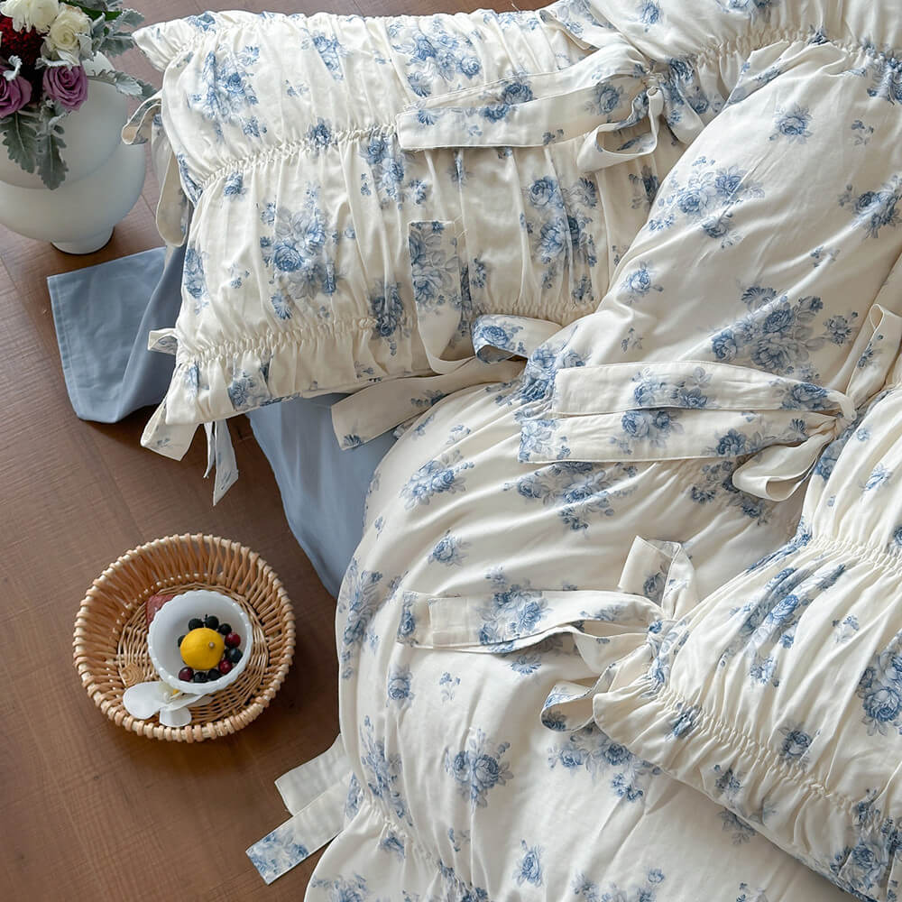 French cottage blue floral bedding with dusty blue sheet and gathered floral pillows