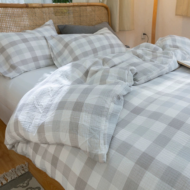 Cozy close-up of the light grey plaid gauze cotton bedding set, focusing on the Soft & Breathable texture and casual, relaxed look.