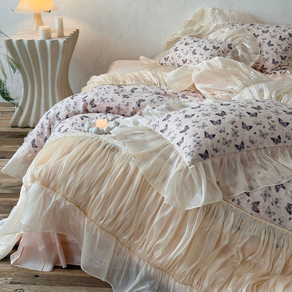 Bed with butterfly bedding and ruffled layers in a bedroom setting.