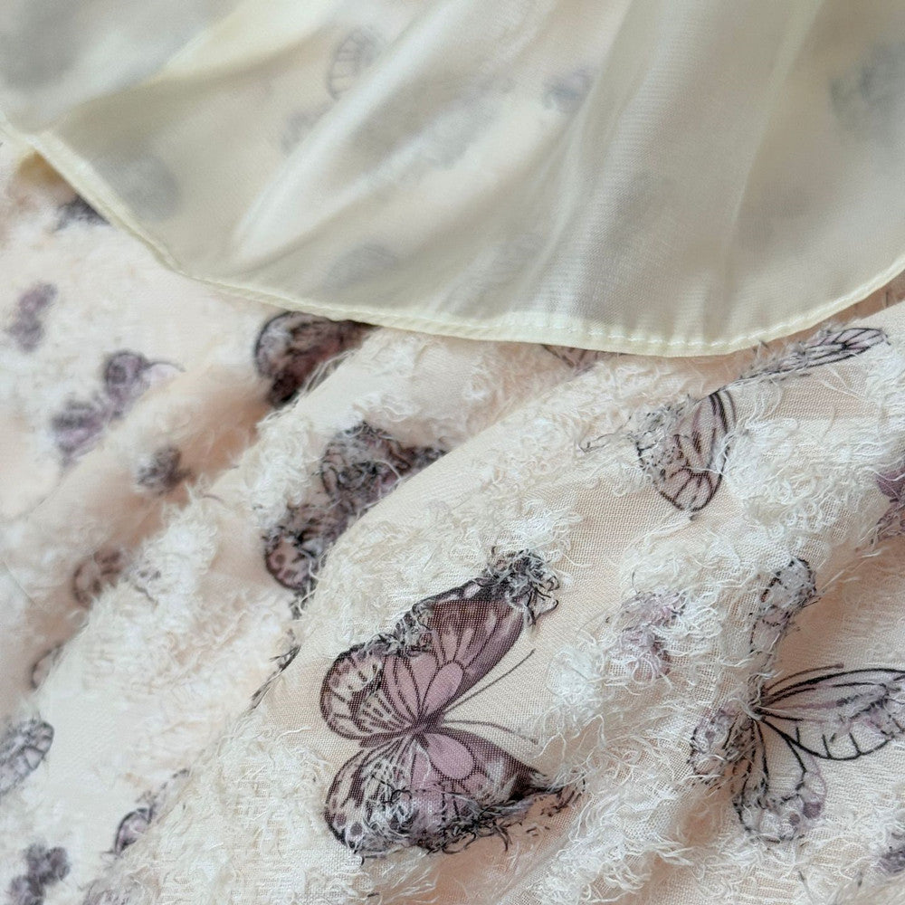 Close-up of a fabric with butterfly patterns and a beige border.