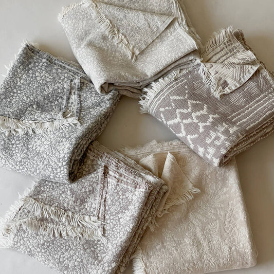 Set of textured throws in neutral colors on a light backgroud