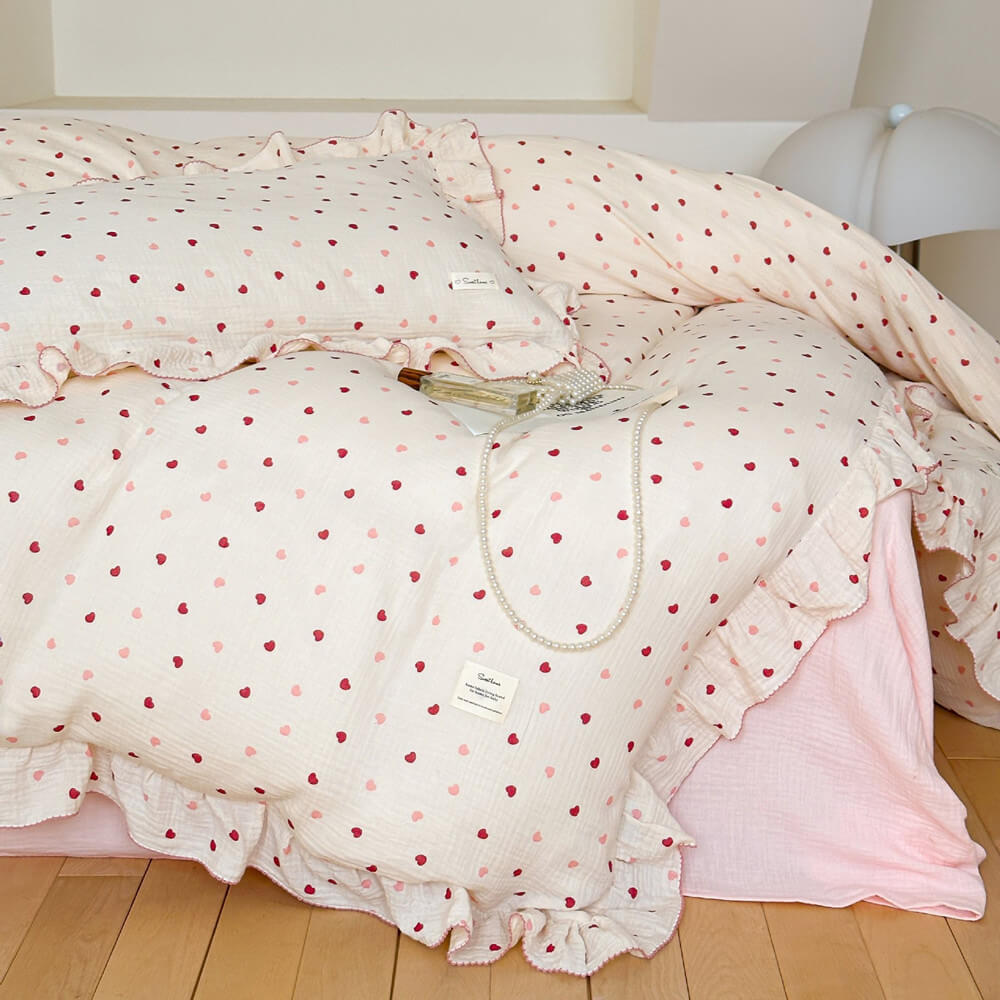 Detail of the Heart Print Bedding and Girls Ruffle Duvet Cover with a pearl necklace accessory on the pillow.