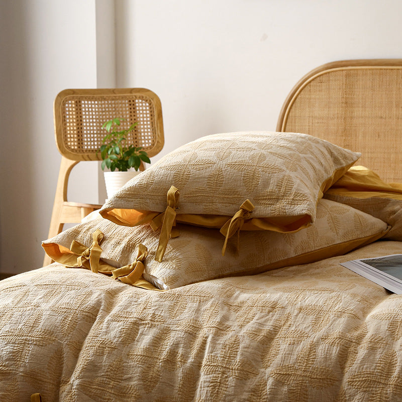 Close-up of Queen Size Bedding Set in yellow, focusing on the intricate jacquard weave and pillow shams with bows.