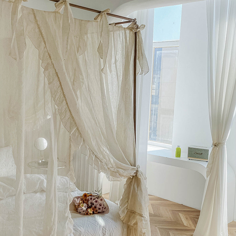 Romantic ruffled canopy curtains on a 4-poster bed in a bright, airy bedroom with natural light