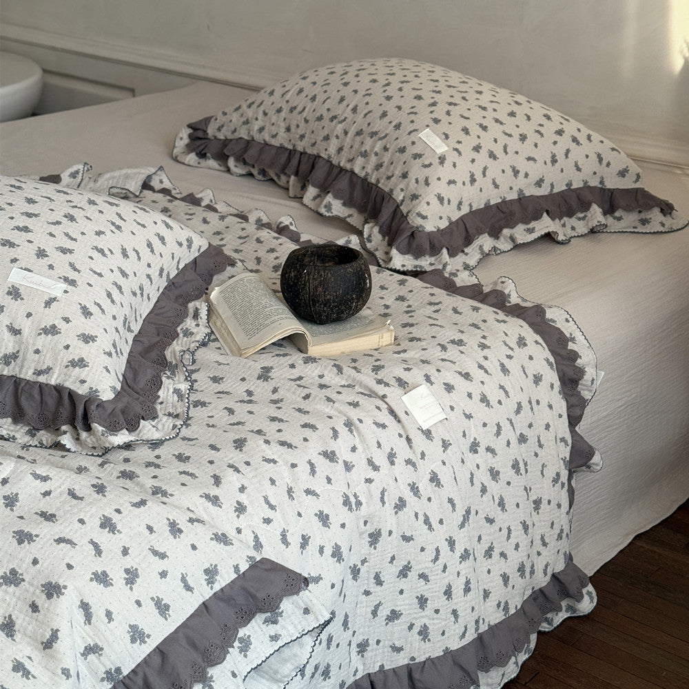 Cotton gauze comforter with dusty blue floral print and soft ruffles