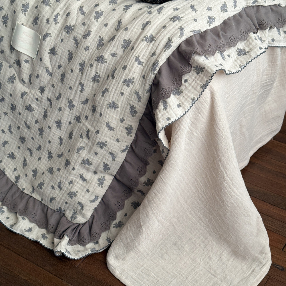 Detail view of ruffled edge and floral pattern on lightweight comforter