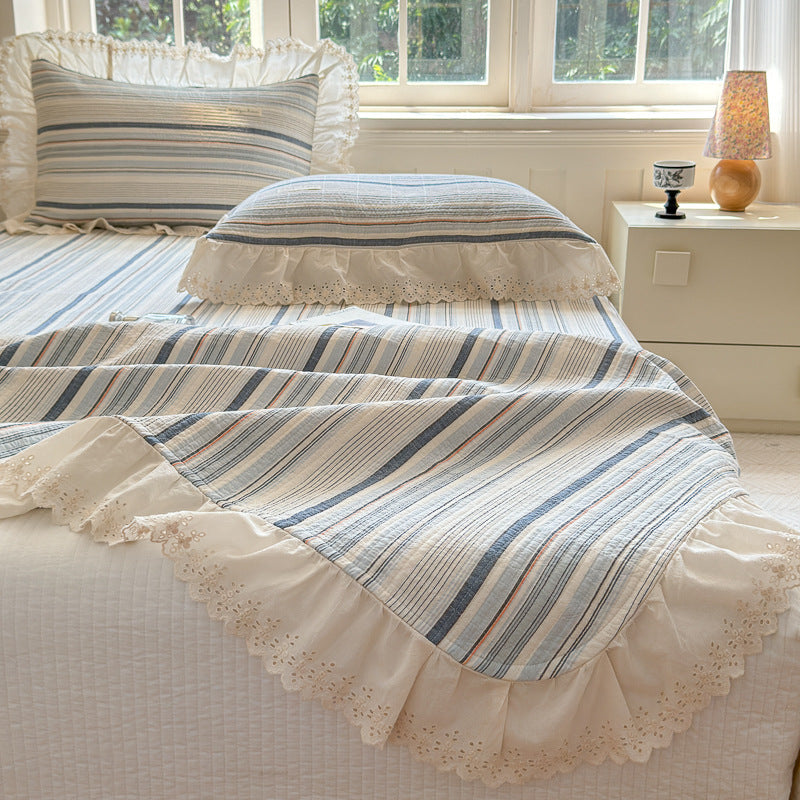 Ruffled stripe cotton bedding set with lace trim on pillows and duvet in sunlit bedroom