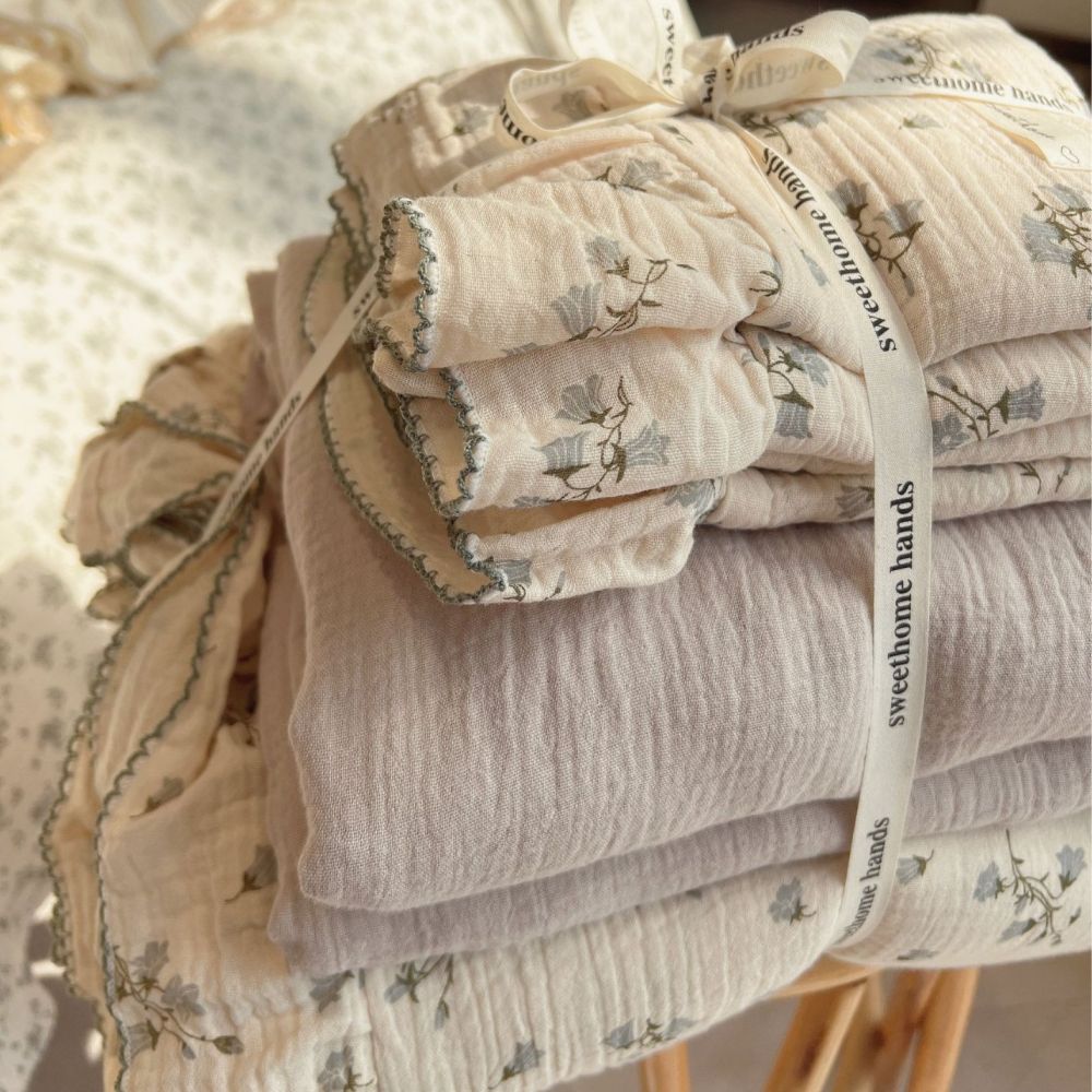 Stacked cotton gauze duvet cover and solid gray fabric tied with ribbon.