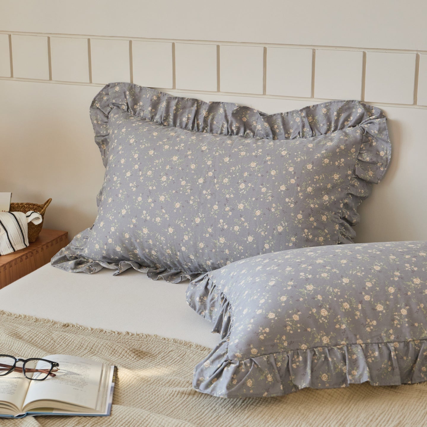 Grey floral cotton muslin pillow shams with ruffle edges, offering a serene and rustic touch to bedroom decor