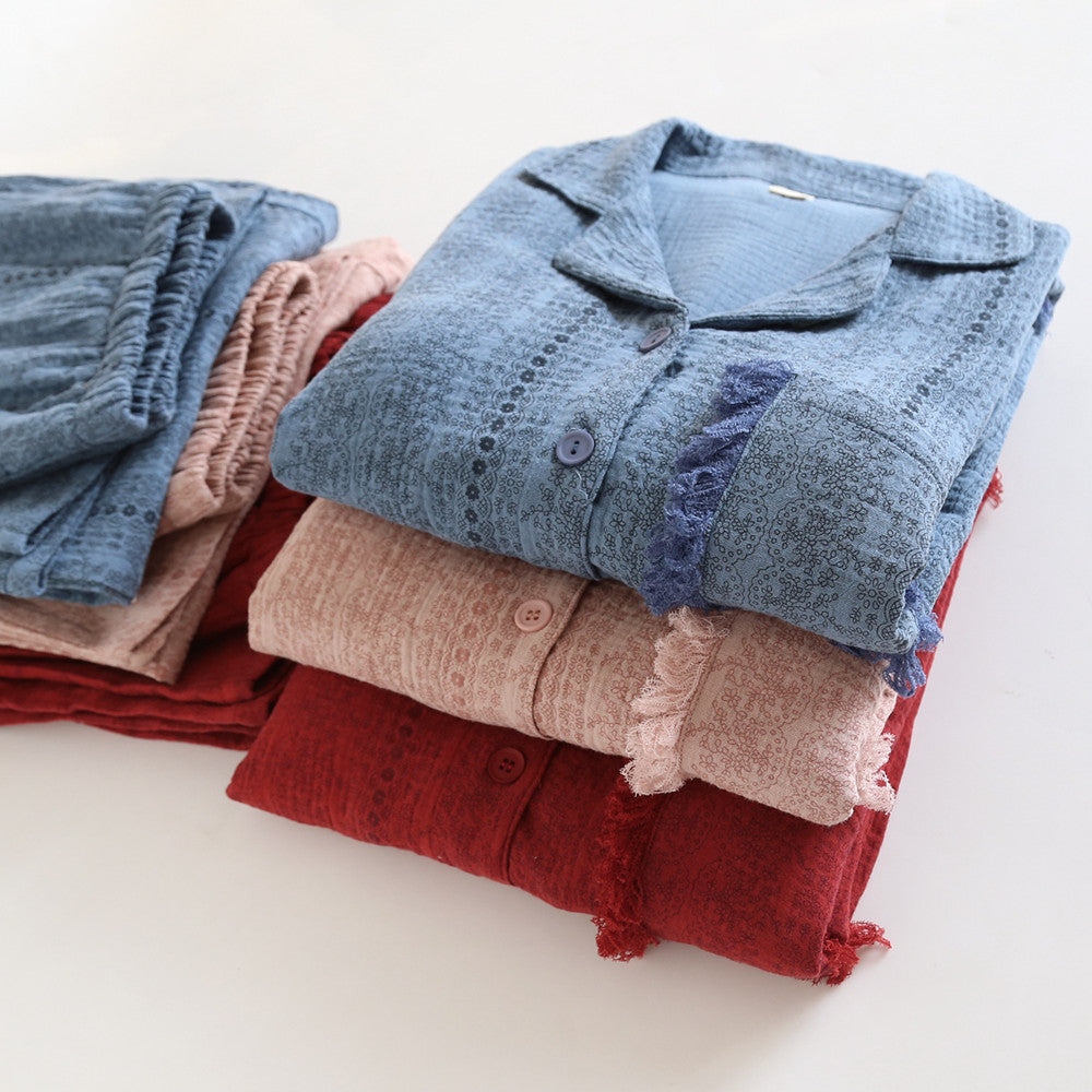 Soft cotton gauze pajama sets in blue, pink, and red, folded neatly on a white surface.