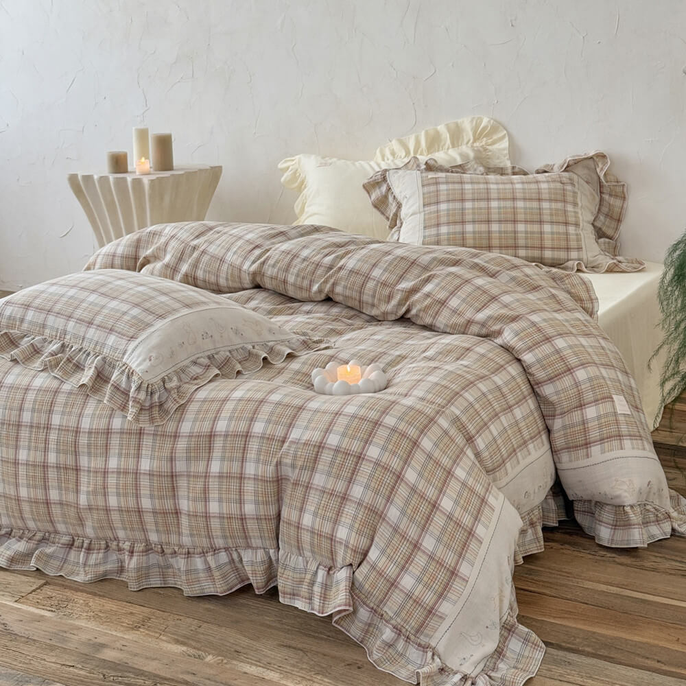 Cozy beige plaid bedding set with ruffled trim and subtle embroidery, styled in a minimalist bedroom