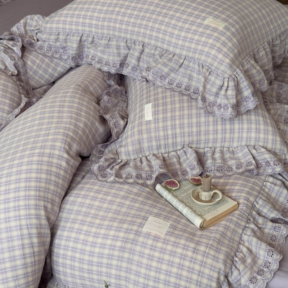 Lavender plaid ruffled duvet cover set styled with book and candle, showing soft muslin texture