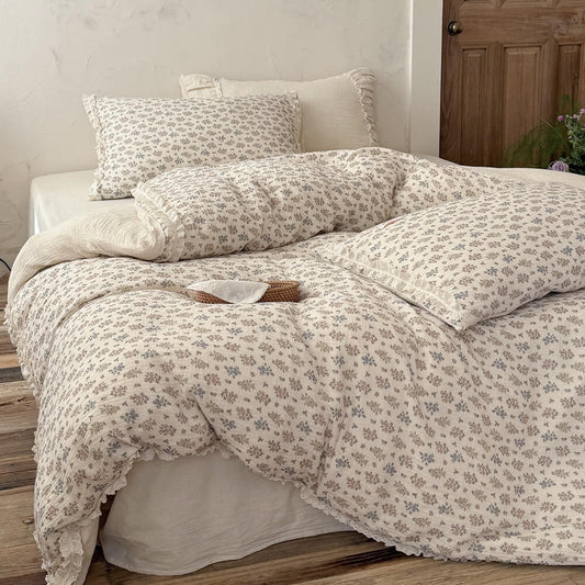 Front view of a beautifully styled cottagecore bed with a lightweight vintage floral comforter and a small decorative rattan basket.