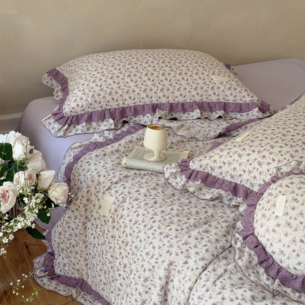 Lightweight floral comforter draped over wooden floor and soft sheet