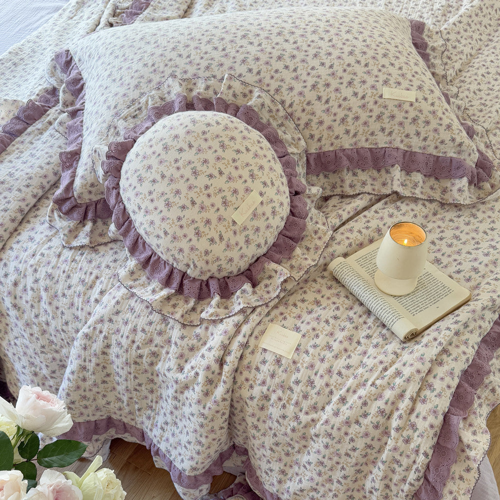 Soft purple bedding with floral quilt and ambient lighting