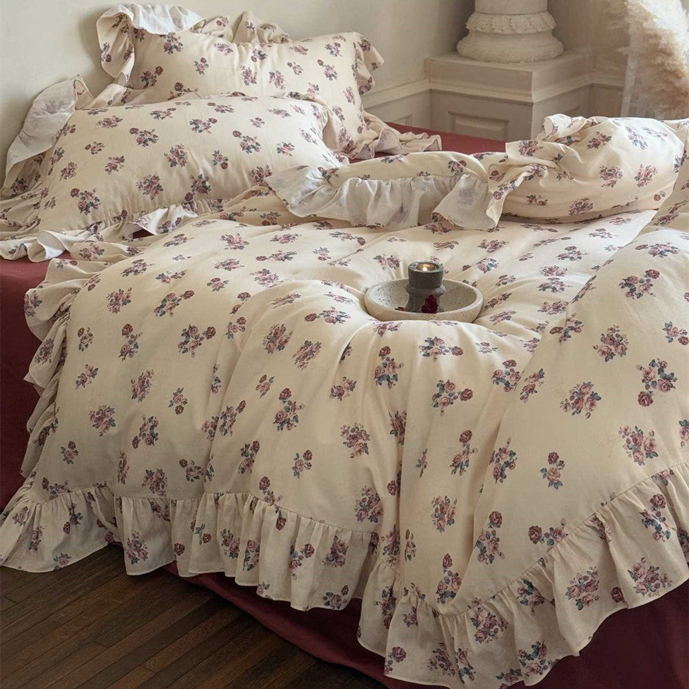 Wide shot of the Vintage Rose Floral Bedding Set on a bed, featuring multiple ruffled pillows and the full drape of the floral duvet cover.