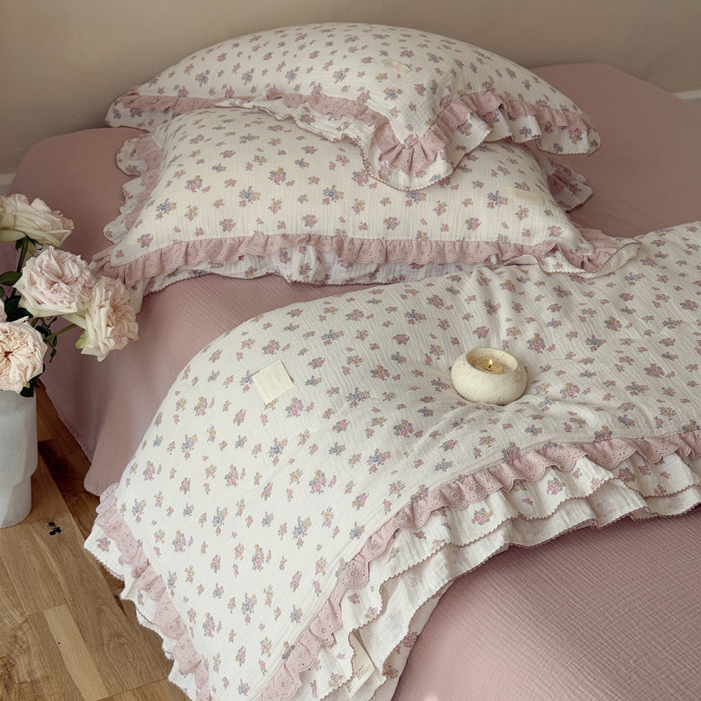 Top view of vintage comforter with blush florals and soft gauze