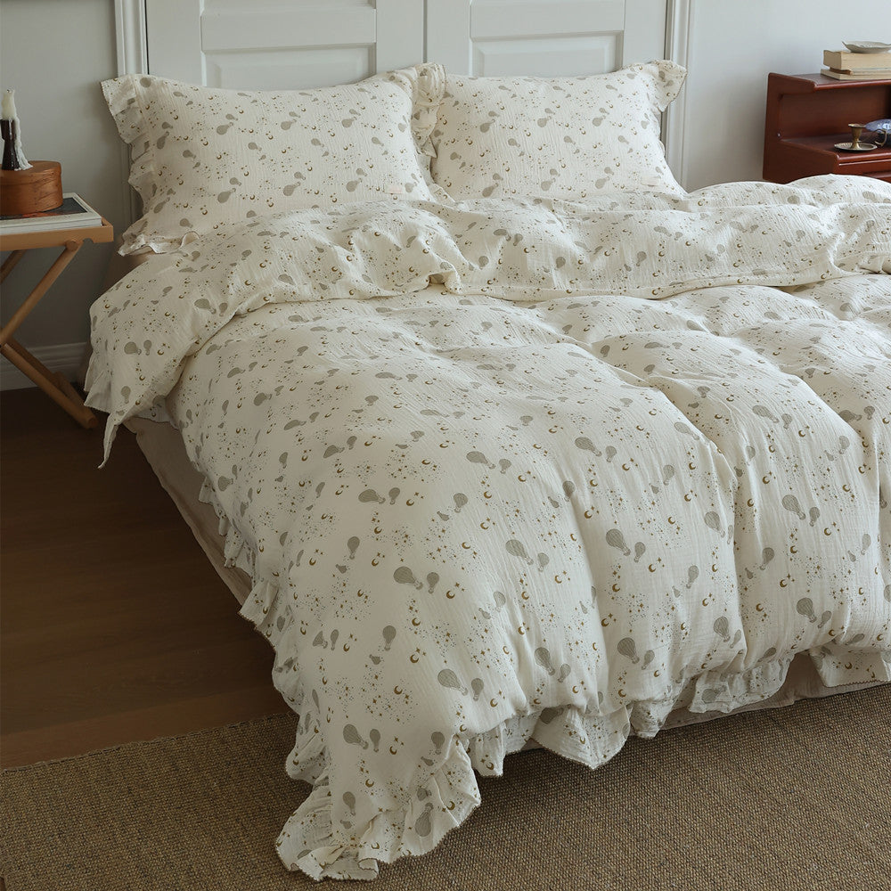 Elegant twin-size duvet cover set made of cotton muslin with a hot air balloon pattern and ruffle detail in a bedroom setting.