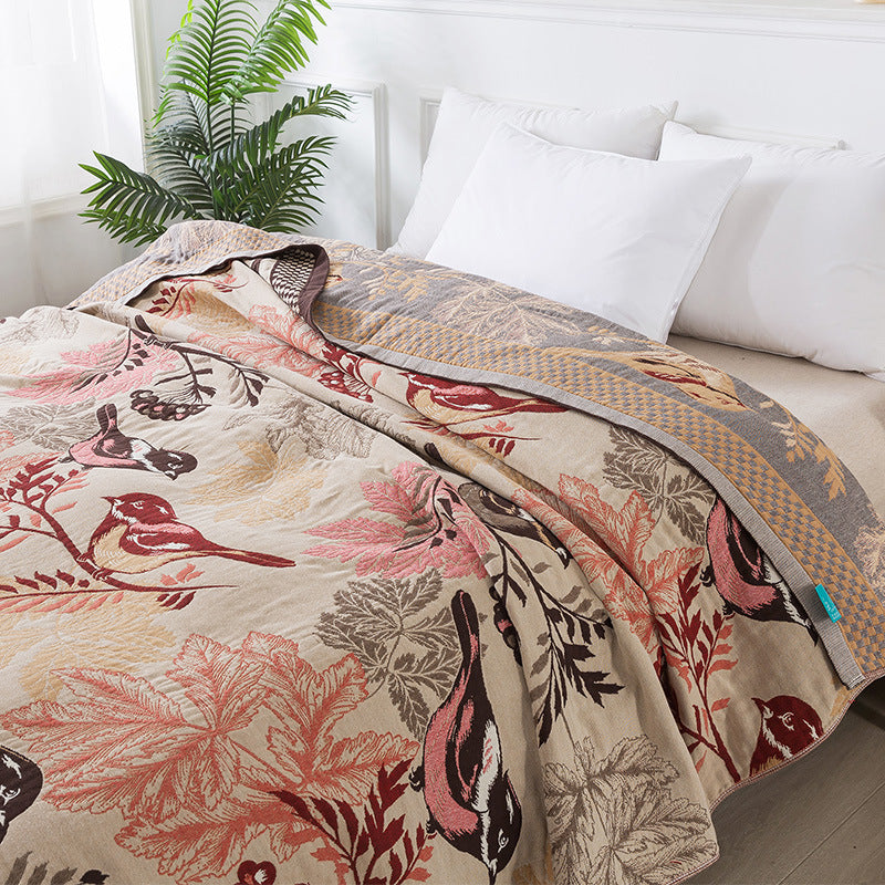 Reversible cotton jacquard throw blanket with chickadee design on bed