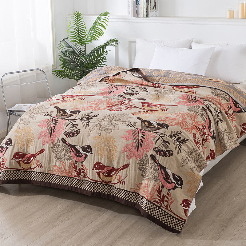 Full side view of autumn chickadee throw blanket draped across a modern bed