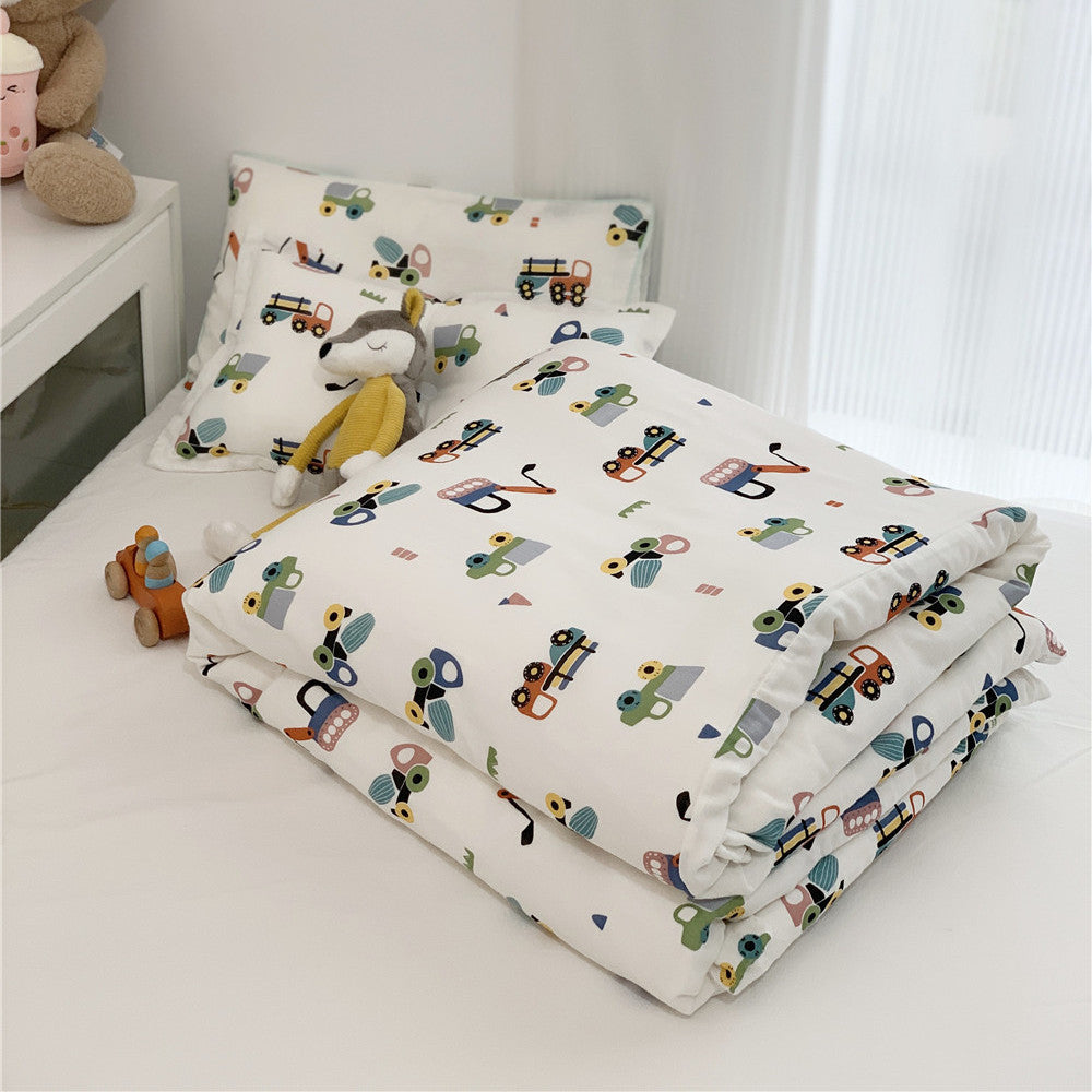 Folded Twin Size Bamboo Duvet Cover and pillow set with a bright construction vehicle print on a white bed.