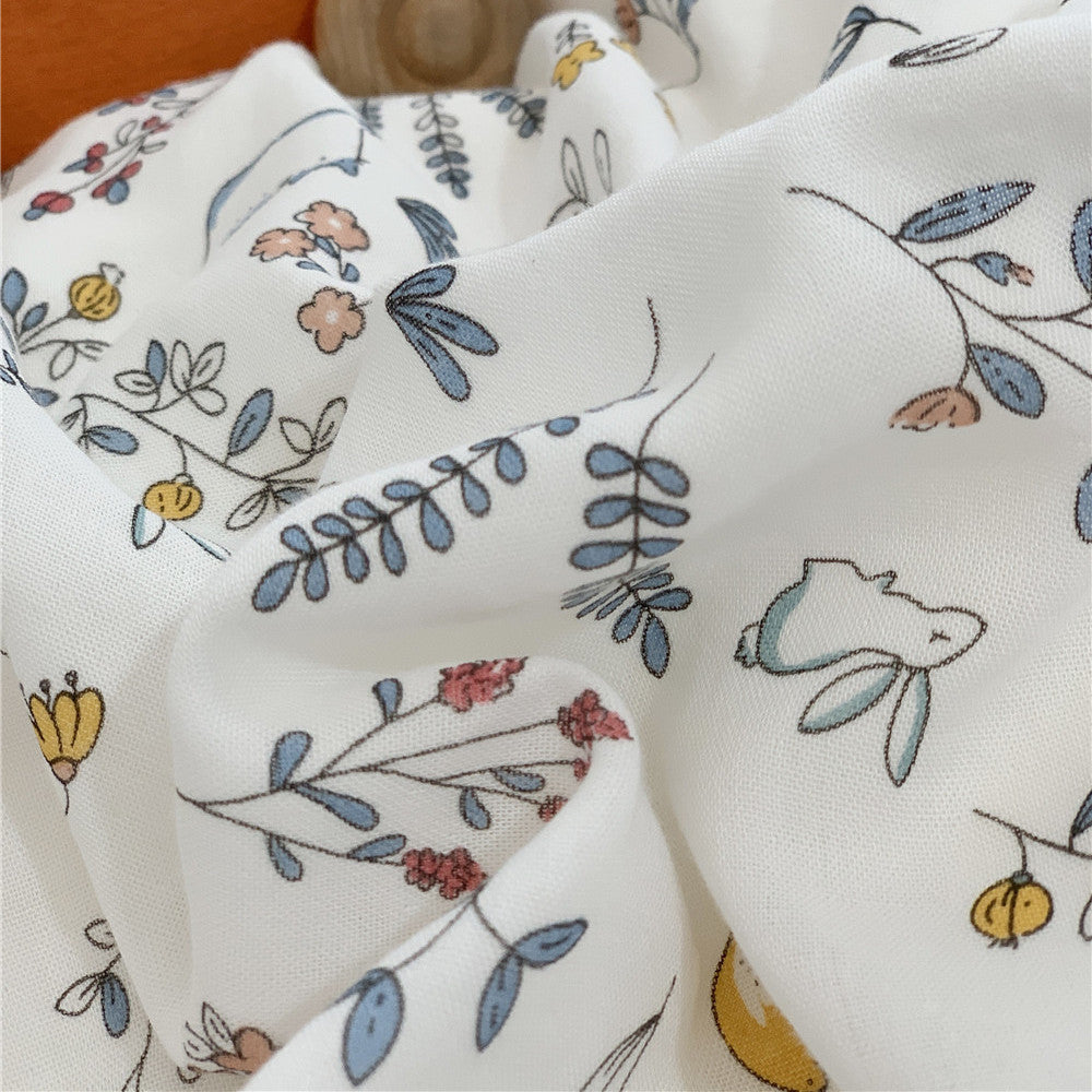 Detailed close-up of the bamboo fabric showing a delicate pattern of blue leaves, yellow flowers, and tiny bunnies.