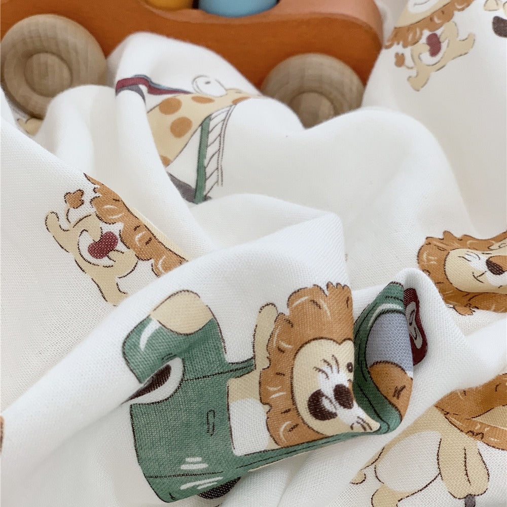 Close-up detail of the breathable bamboo duvet cover fabric with a cute lion and giraffe in a green truck motif.
