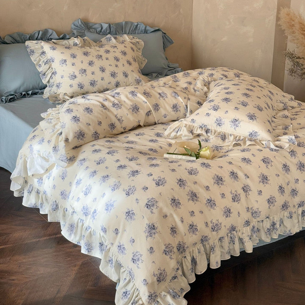 Full view: Shabby Chic blue rose floral bedding set with ruffled edging and solid blue accent pillows.