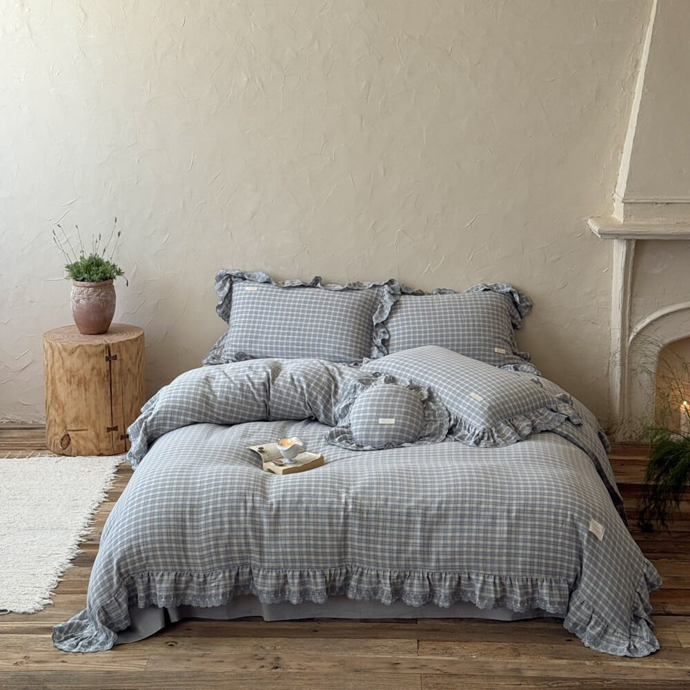 Bed with dusty blue bedding set in a cozy bedroom