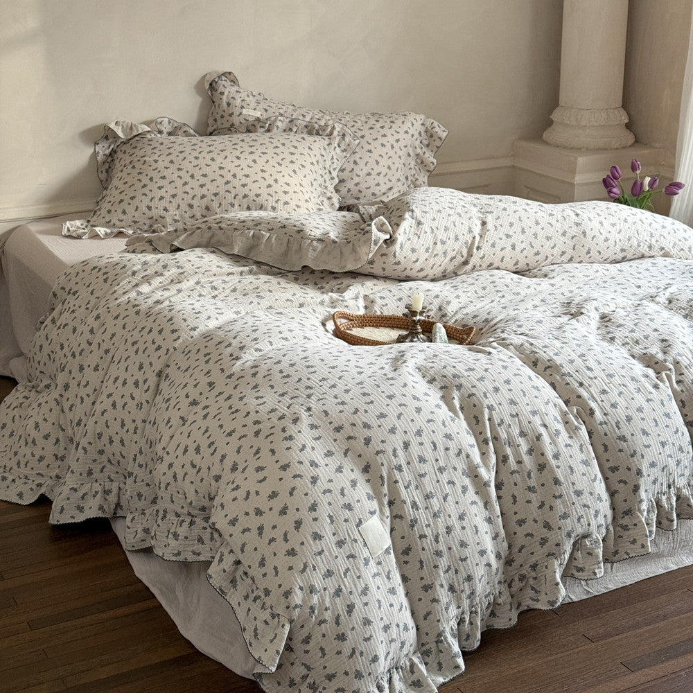 Grey floral duvet cover with ruffle details, arranged on a bed with a matching pillow.