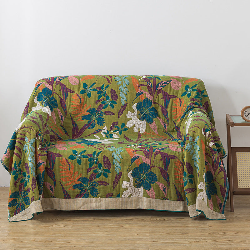 Reversible cotton throw blanket with green floral side on sofa