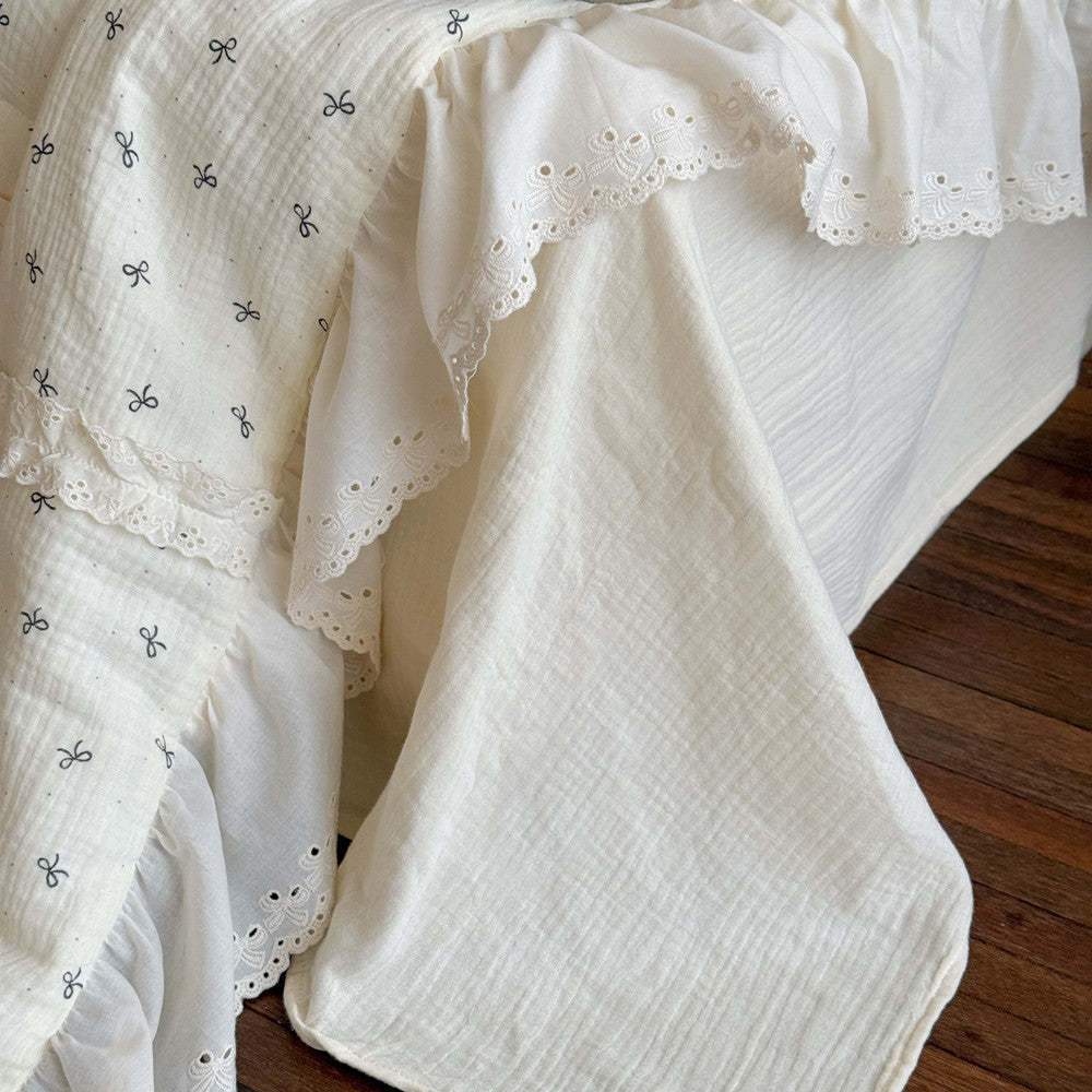 Girly comforter styled on twin bed with solid flat sheet