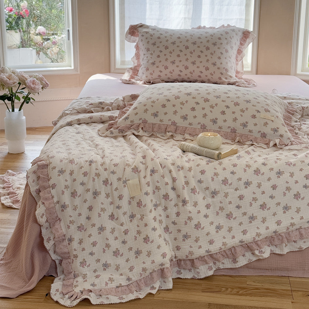 Cotton comforter with book and candle beside bed in calm interior