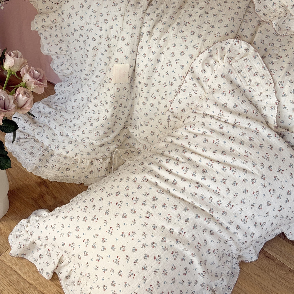 Draped floral comforter in crinkled cotton gauze, showing lace and fabric texture