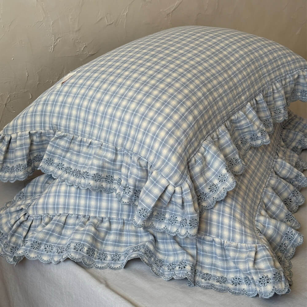 Detail shot of ruffled edge and plaid cotton muslin on pillowcase