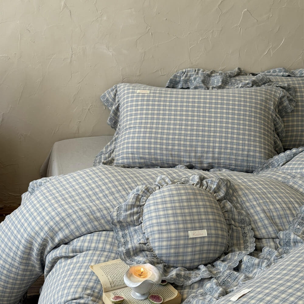 Close-up of dusty blue plaid cotton muslin bedding with elegant ruffled trim