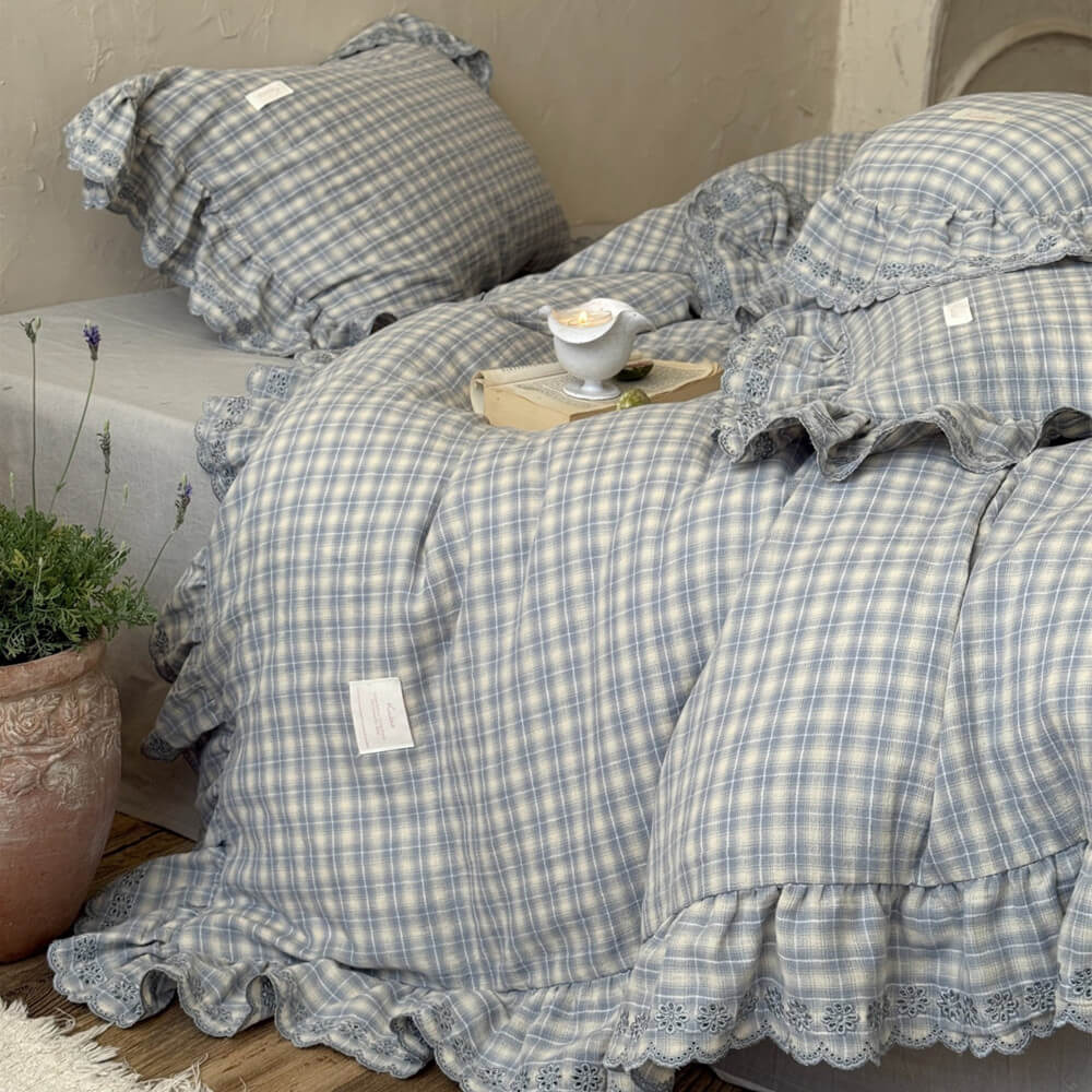 Bedside scene with dusty blue plaid ruffle bedding and wood decor