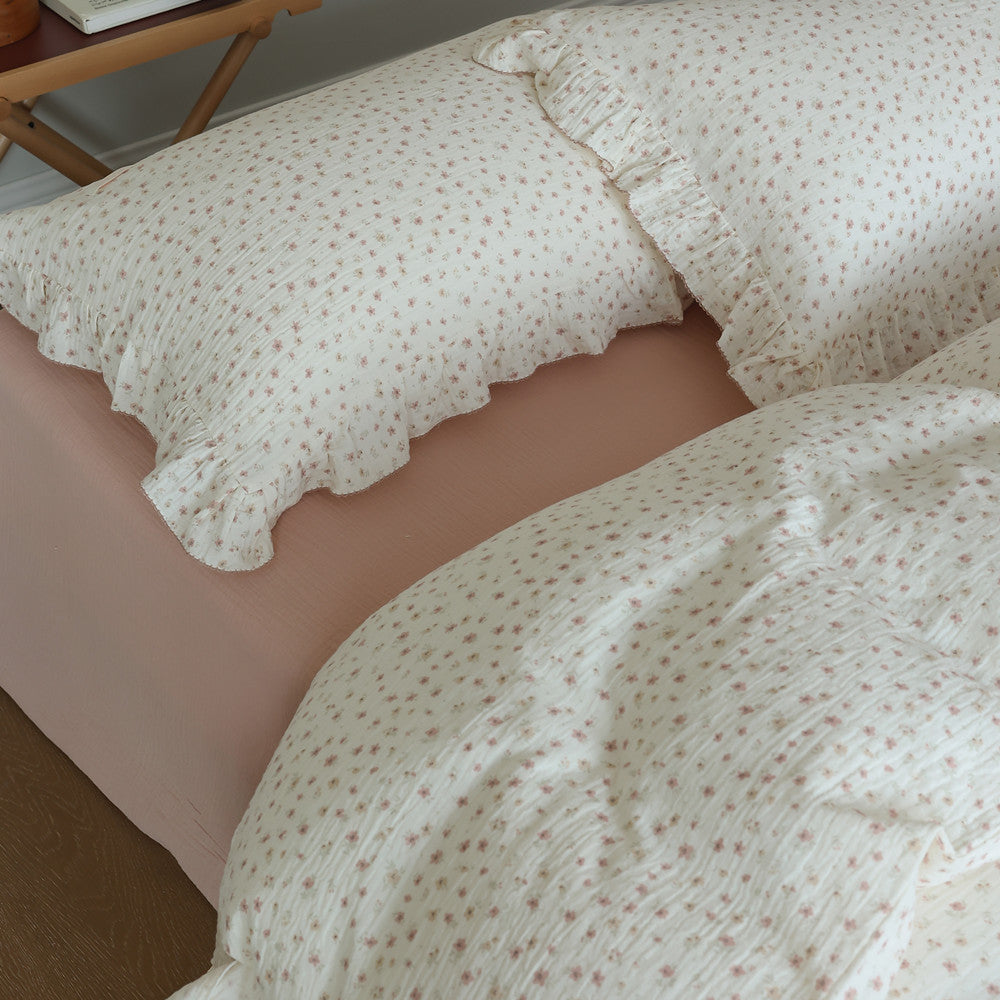 Detail shot of ditsy floral cotton gauze duvet cover and pillow shams with ruffles.