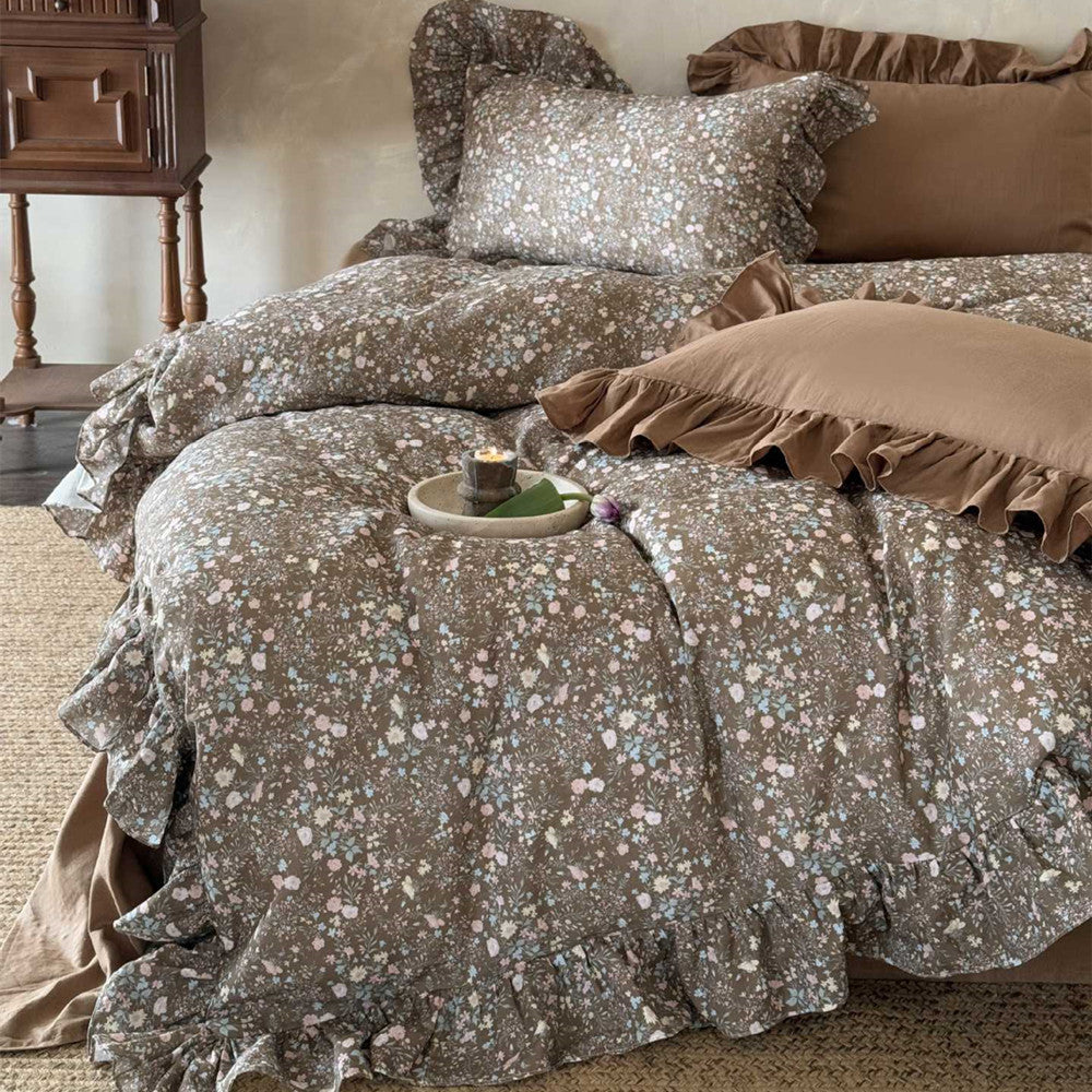 Angled view of the Earthy Floral Bedding Set, showcasing the brown ruffled accents and the subtle pink and blue vintage bloom pattern on the duvet.