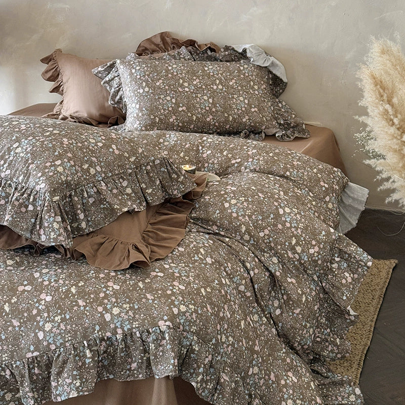 Full bed shot showcasing the relaxed drape of the ruffled cotton muslin duvet and the overall earthy floral theme of the set.