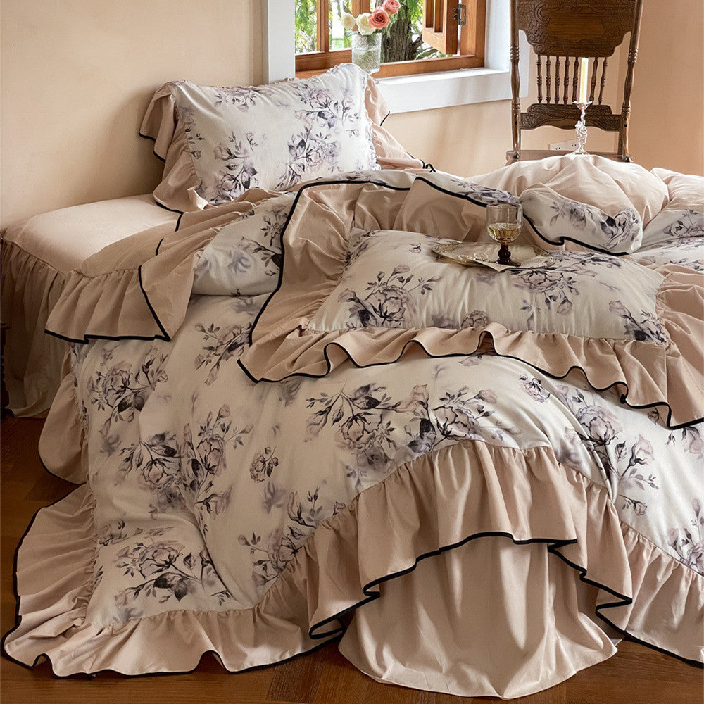 Watercolor floral cotton bedding set with ruffled trim in soft nude tones on the bed