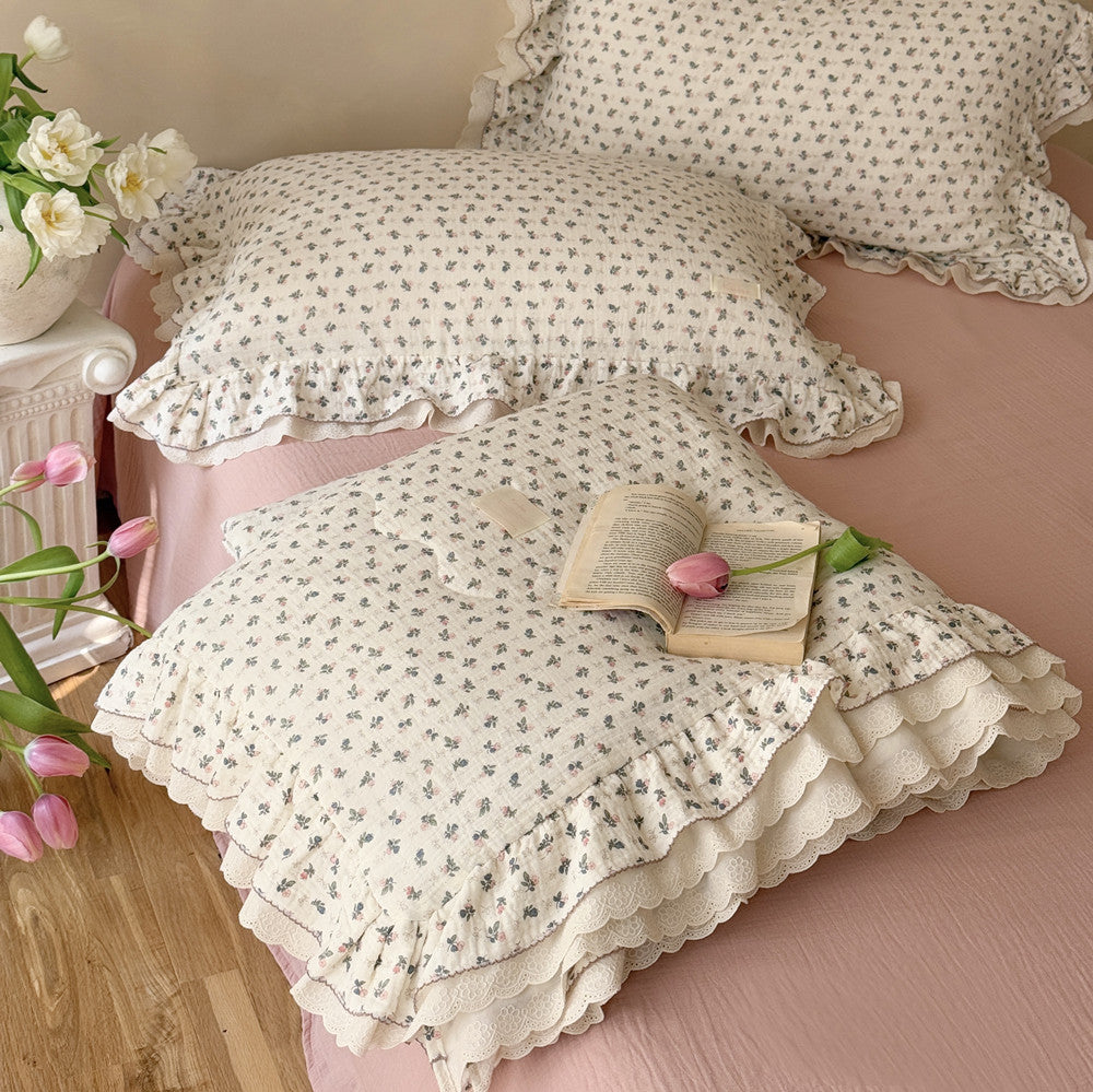 Detail shot of rosebud cotton comforter and open book