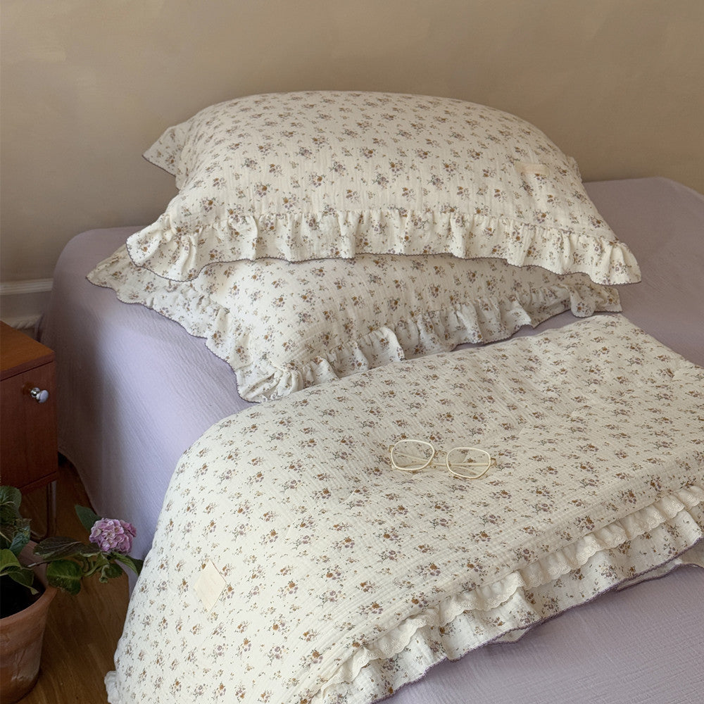Full view of floral comforter with yellow flowers and lavender lace trim